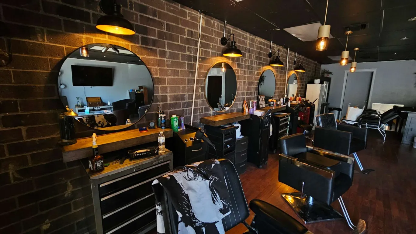 Salon interior with warm pendant lighting and dark wood floors